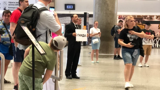 В аэропорту Пулково мужчина в черном фраке встречал с табличкой "гнидА" прибывших людей в Петербург