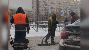 На Долгоозерной улице в разгар снегопада начали укладывать свежий асфальт