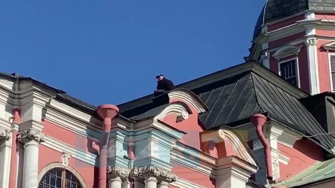 Очевидцы сняли на видео мужчину, который забрался на крышу Александро-Невской Лавры с ножом