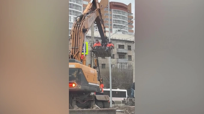 В Красноярске очевидцы сняли на видео рабочих, катавшихся в ковше экскаватора