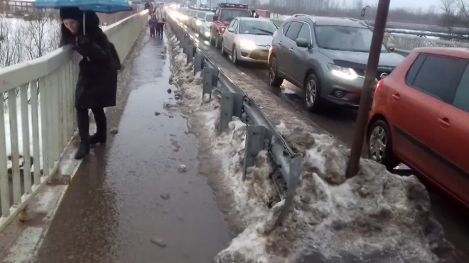 В Мурино потоп охватил пешеходный мост: люди лезут по перилам как обезьяны