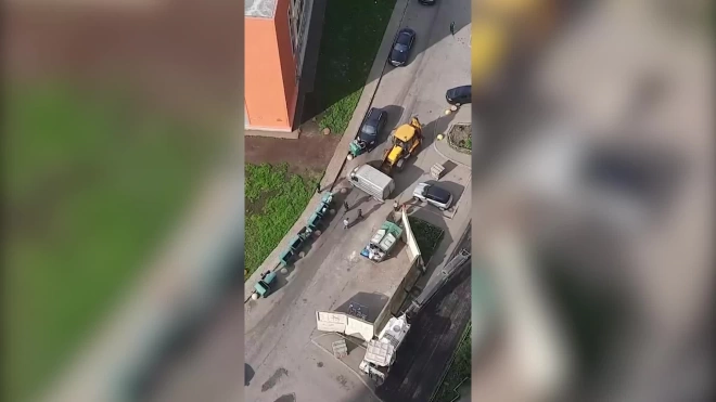 На юго-западе Петербурга дорожники убрали мешающие ремонту машины ковшом трактора