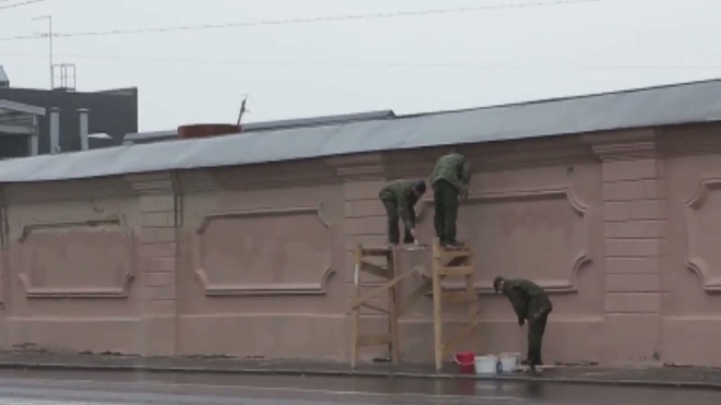 Ради ПЭФа. Несмотря на дождь, военные красят стену вблизи Ленэкспо