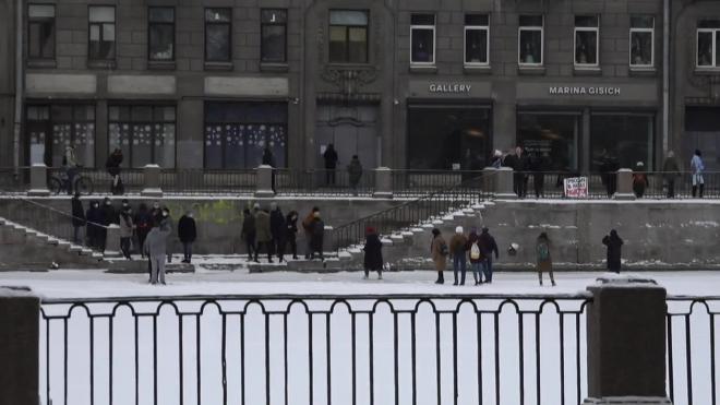 Участники протестного шествия в Петербурге переходят Фонтанку по льду