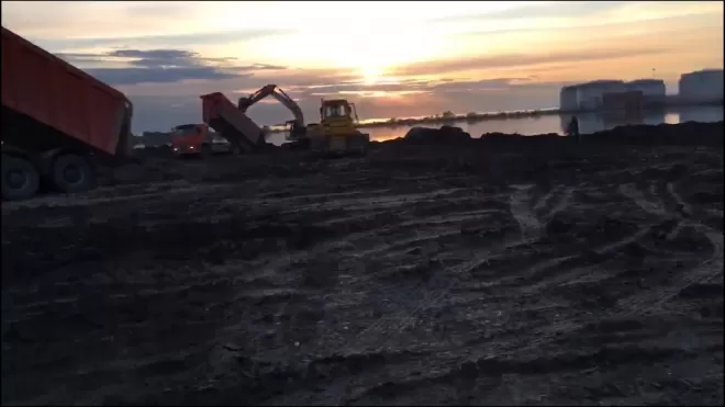 На побережье Финского залива грузовики с табличкой "СКК" свозят строительный мусор