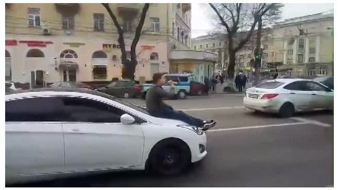 Видео: в Воронеже мужчина проехался на капоте автомобиля с бутылкой пива